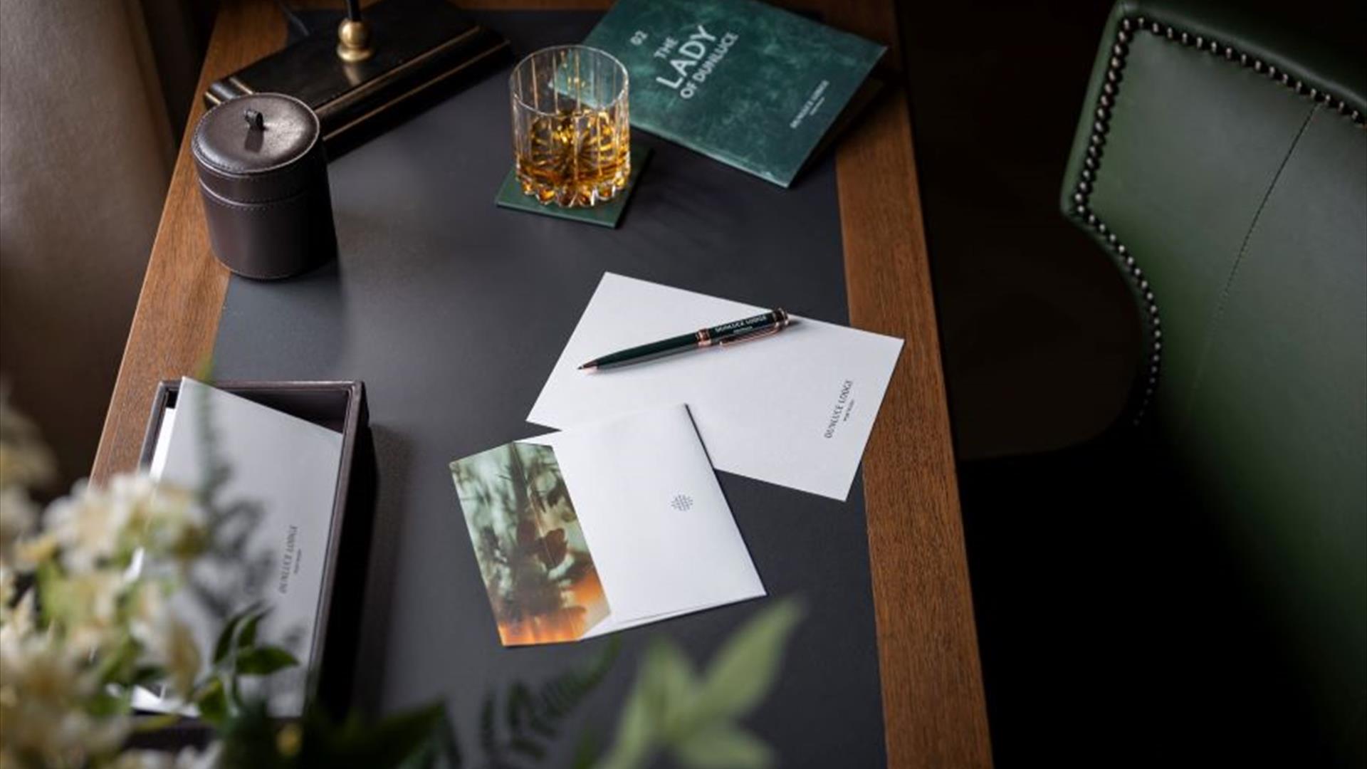 a letter on a pen sit on an old fashioned desk, with various props surrounding