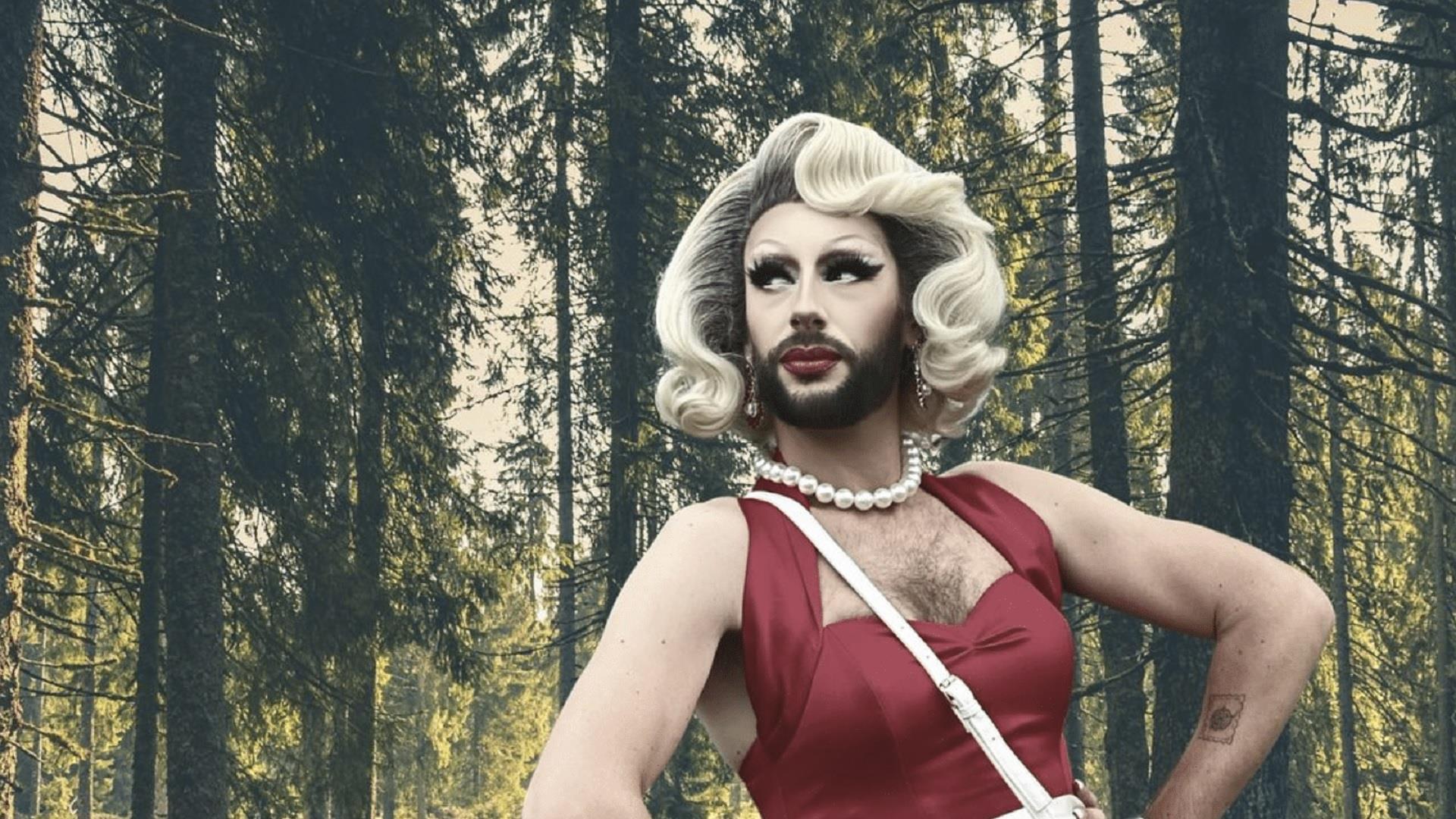 Drag Queen Cherrie On Top pictured against a forest backdrop