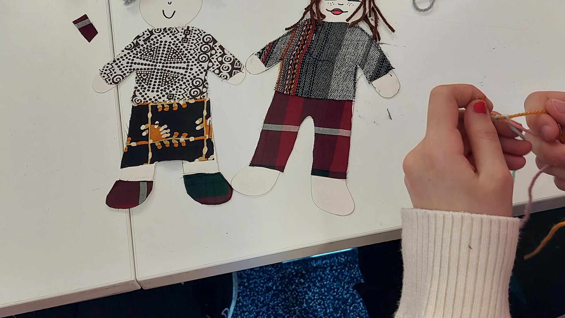 Small cutouts of little people, made from textiles like wool and linen.