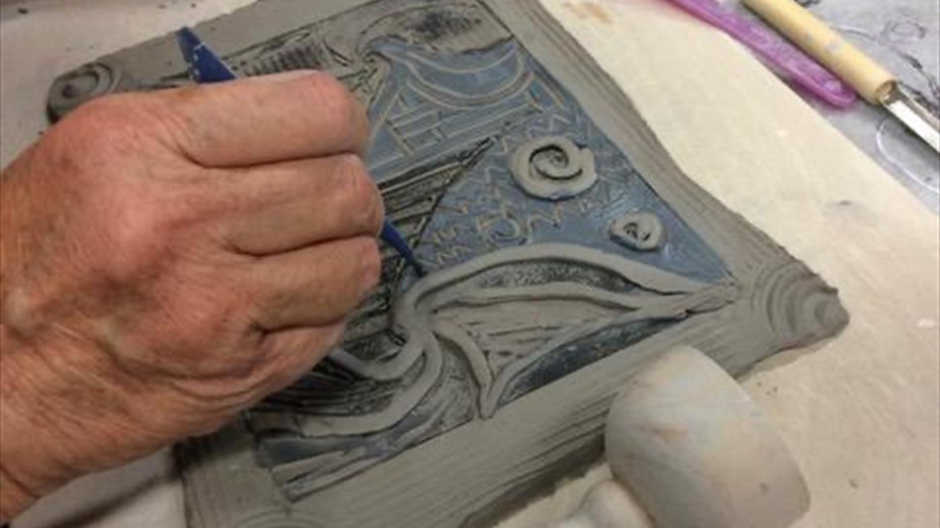 clay tile being carefully engraved