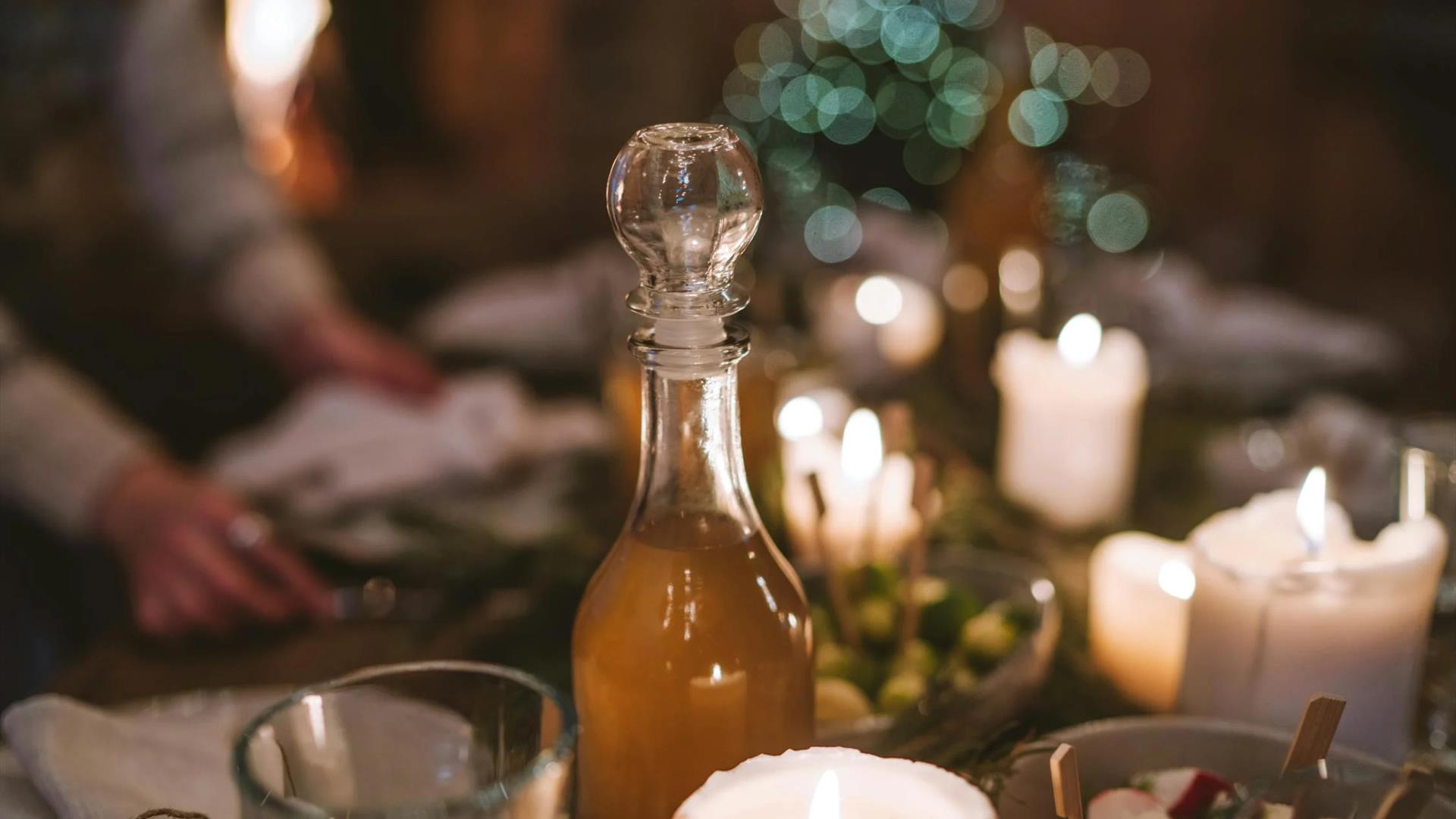 a twinkly festive picture of glass stopped bottle and candles.