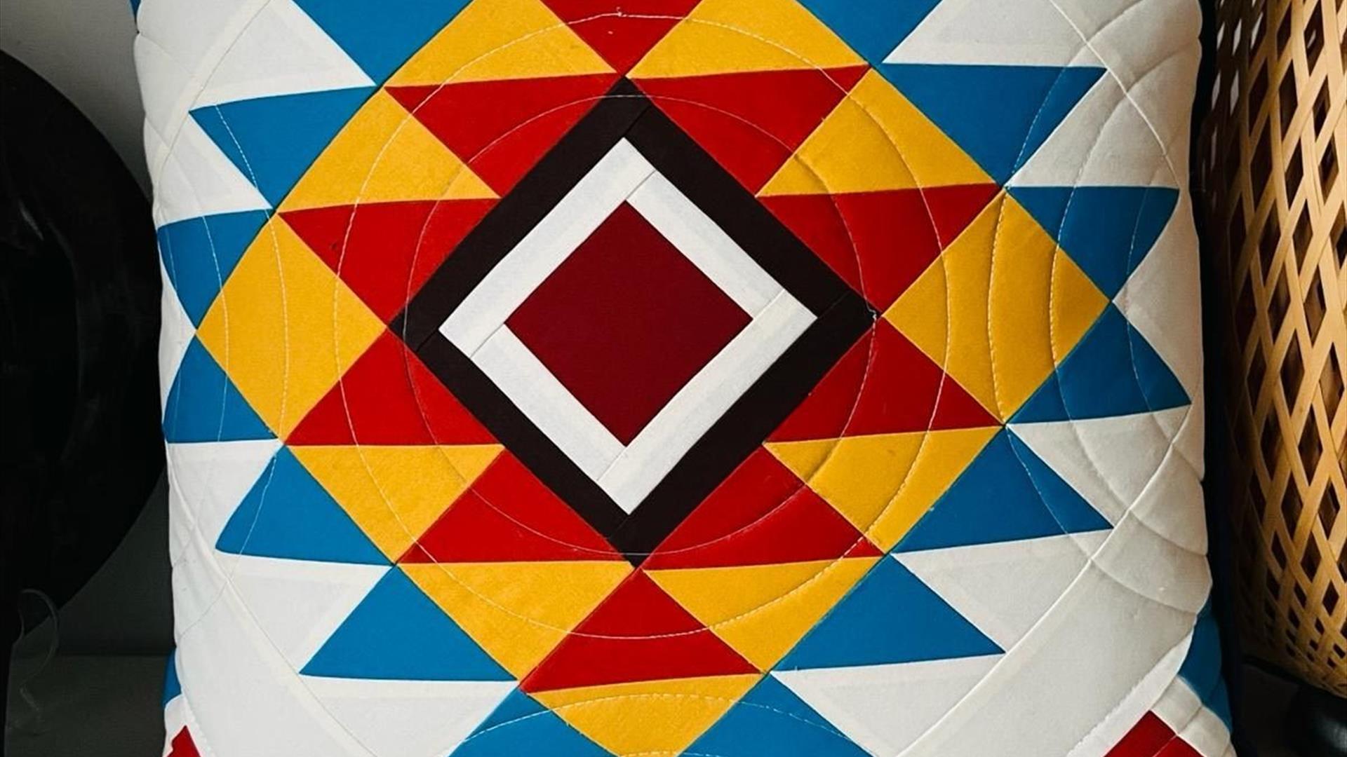 quilted pillow with a colourful, geometric pattern