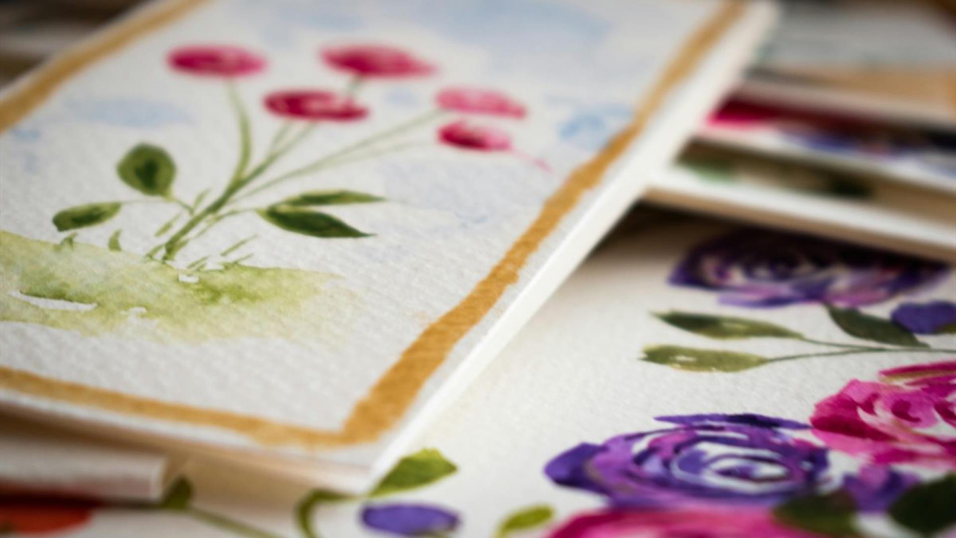 various watercolour pieces by leona devine. the foremost piece depicts a bunch of pink flowers in bloom