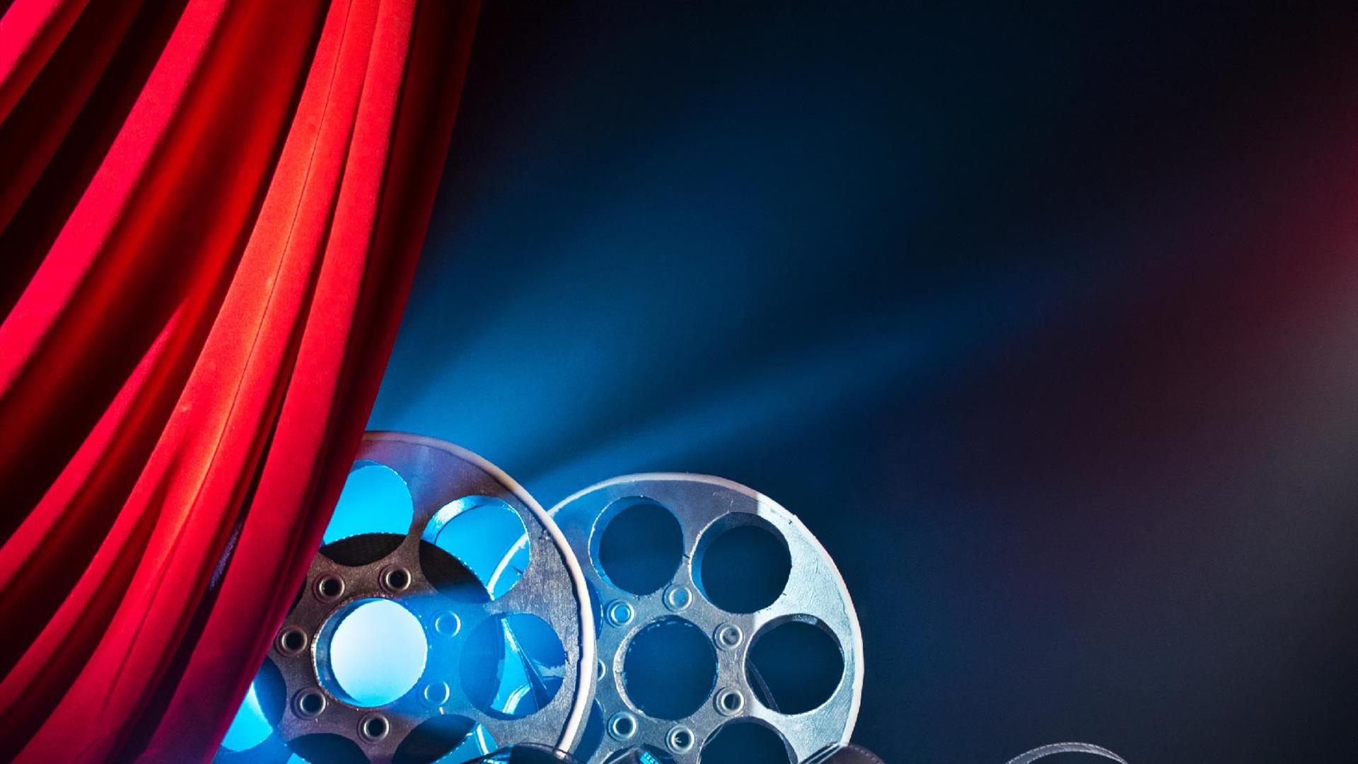 cinema film reels behind a red curtain