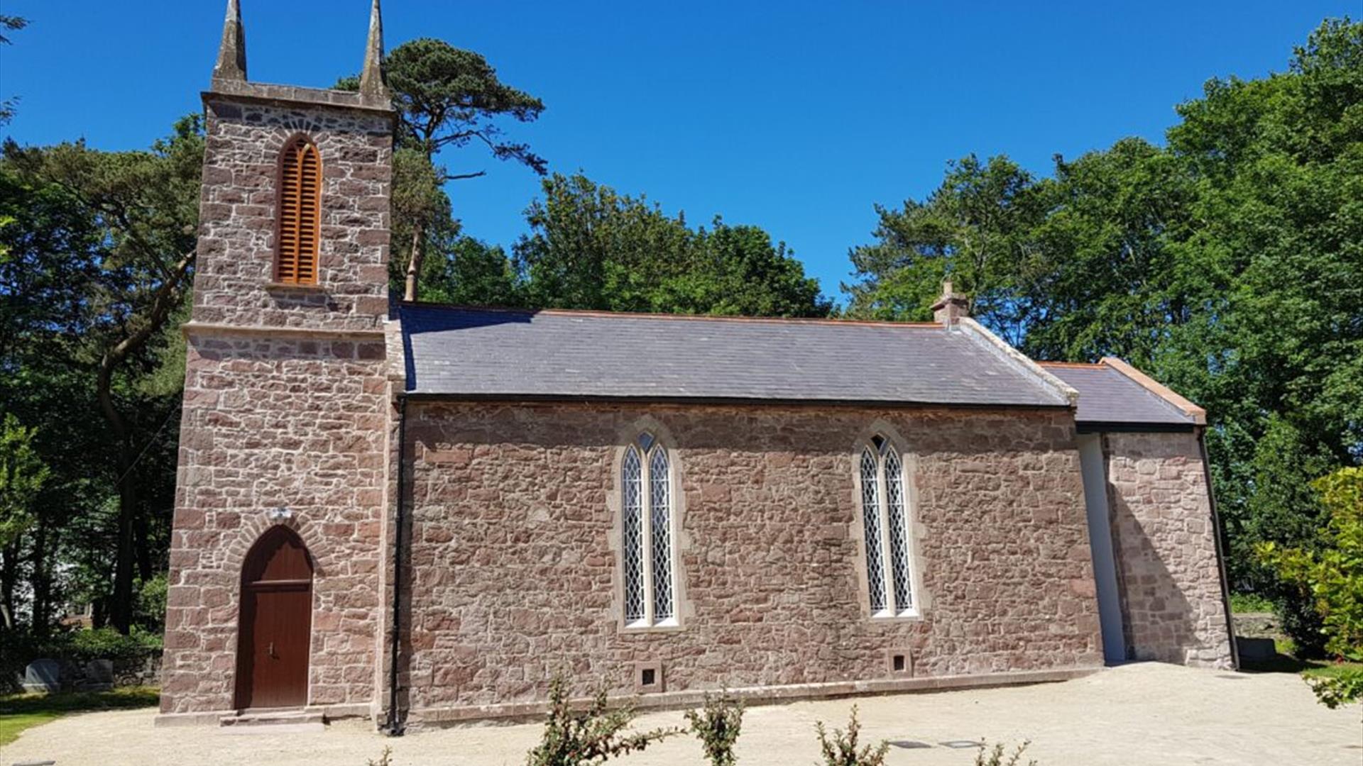 Old stone church building with blue sky beyond