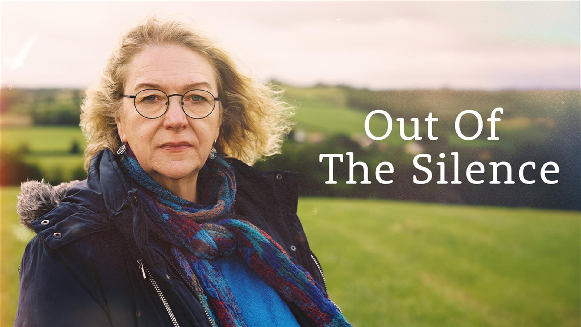 A woman with blond hair and round spectacles stands in a field looking towards the camera. Beside her the title "Out of the Silence" is written in whi