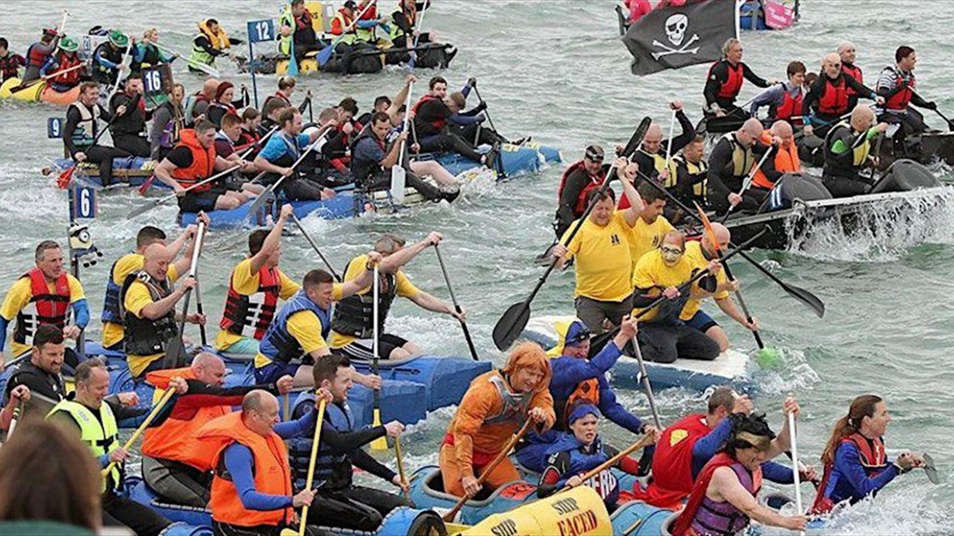 a number of people in rafts all racing each other on the water