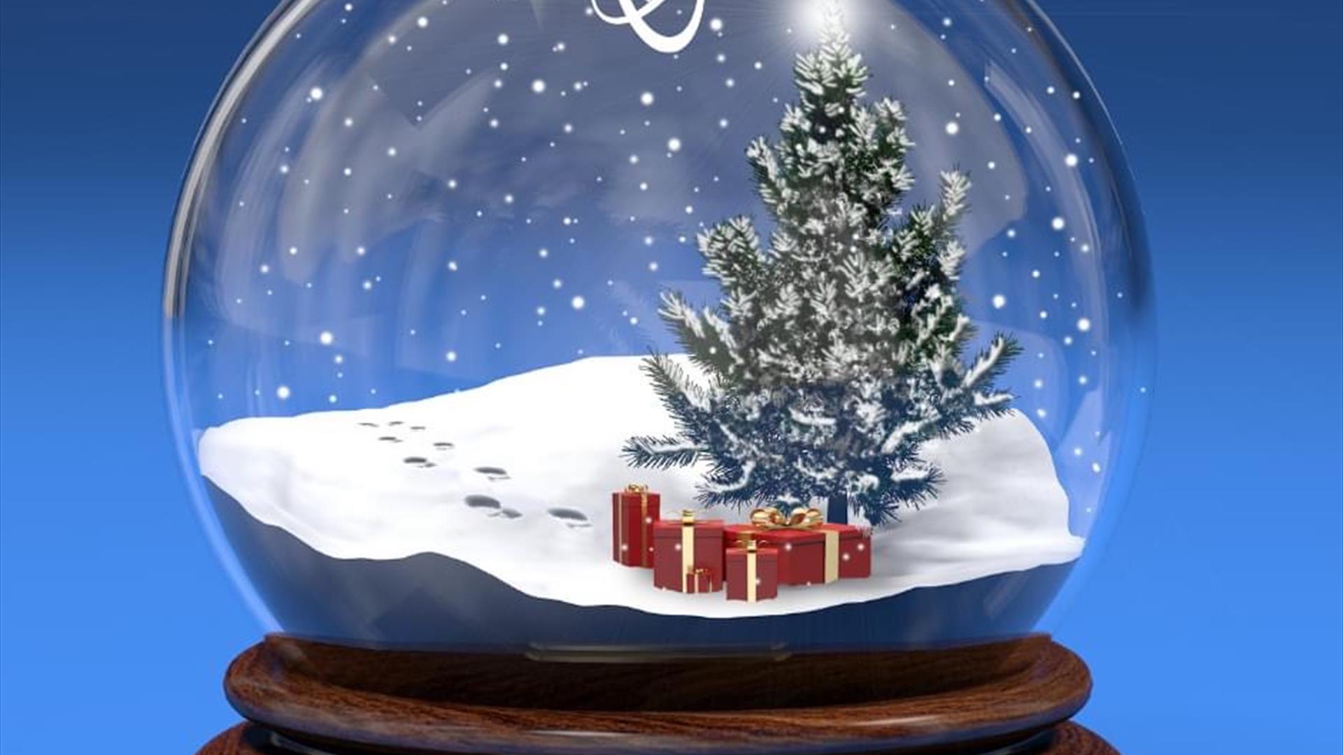 a festive snow globe with a tree and presents inside.