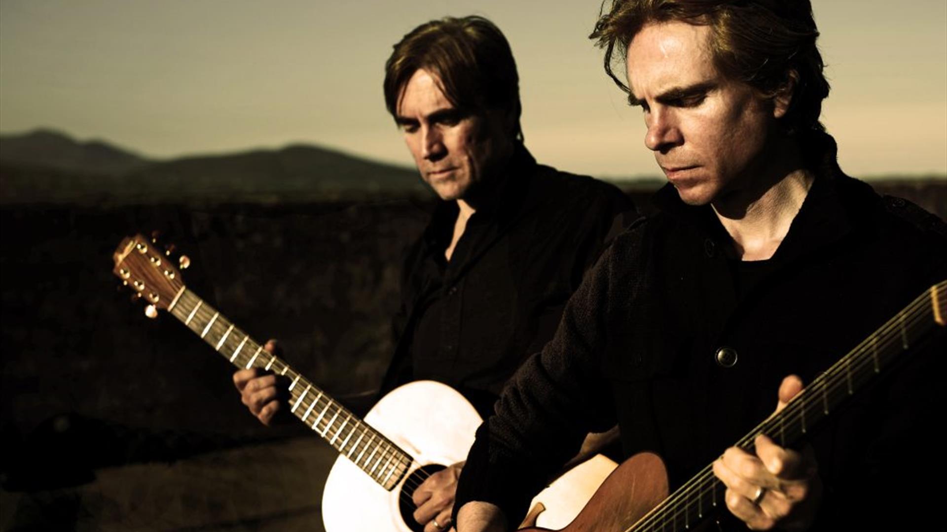 image of Brendan and Declan Murphy standing outside with guitars at dusk