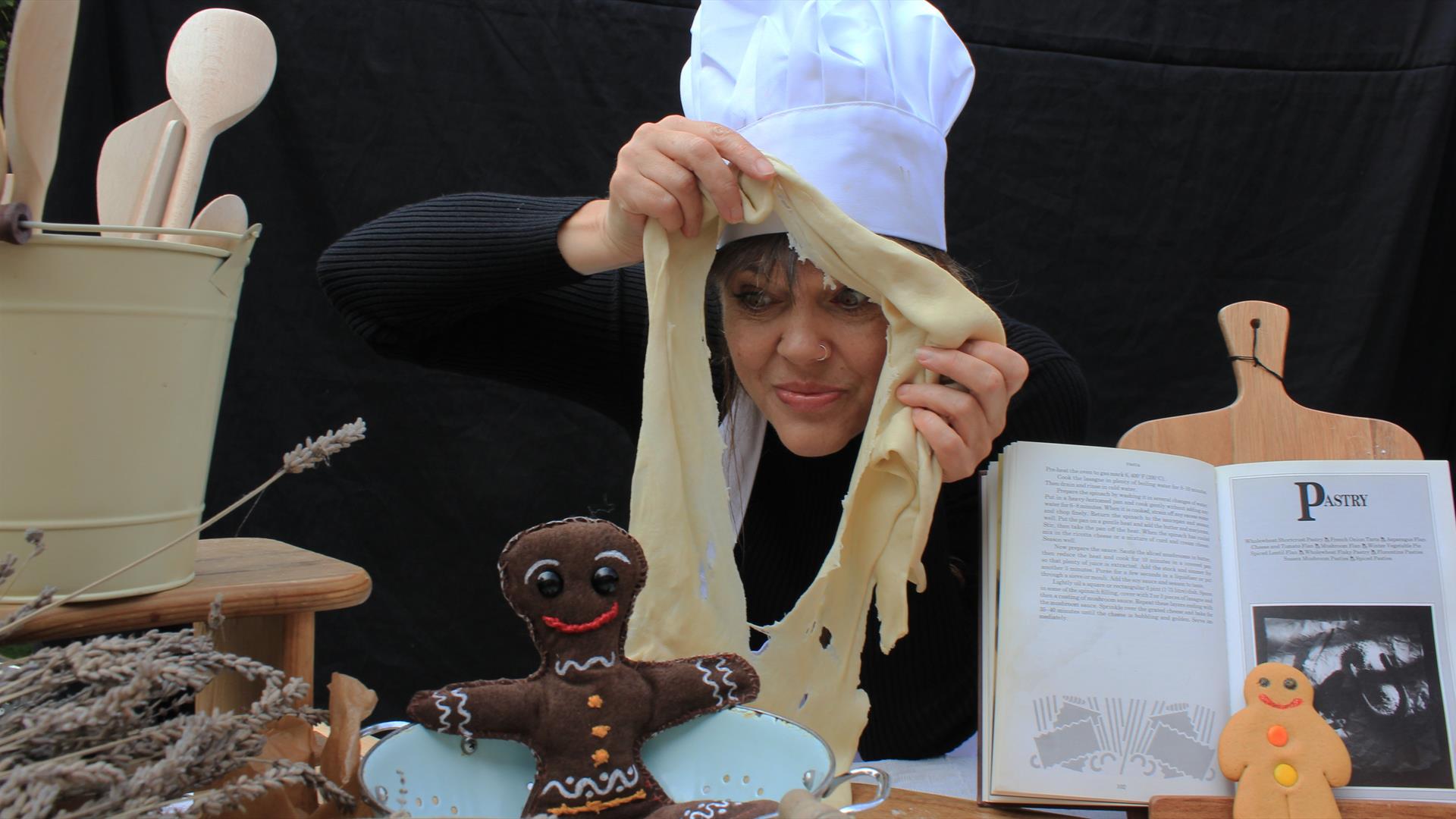 A woman in a chef's hat with pastry.