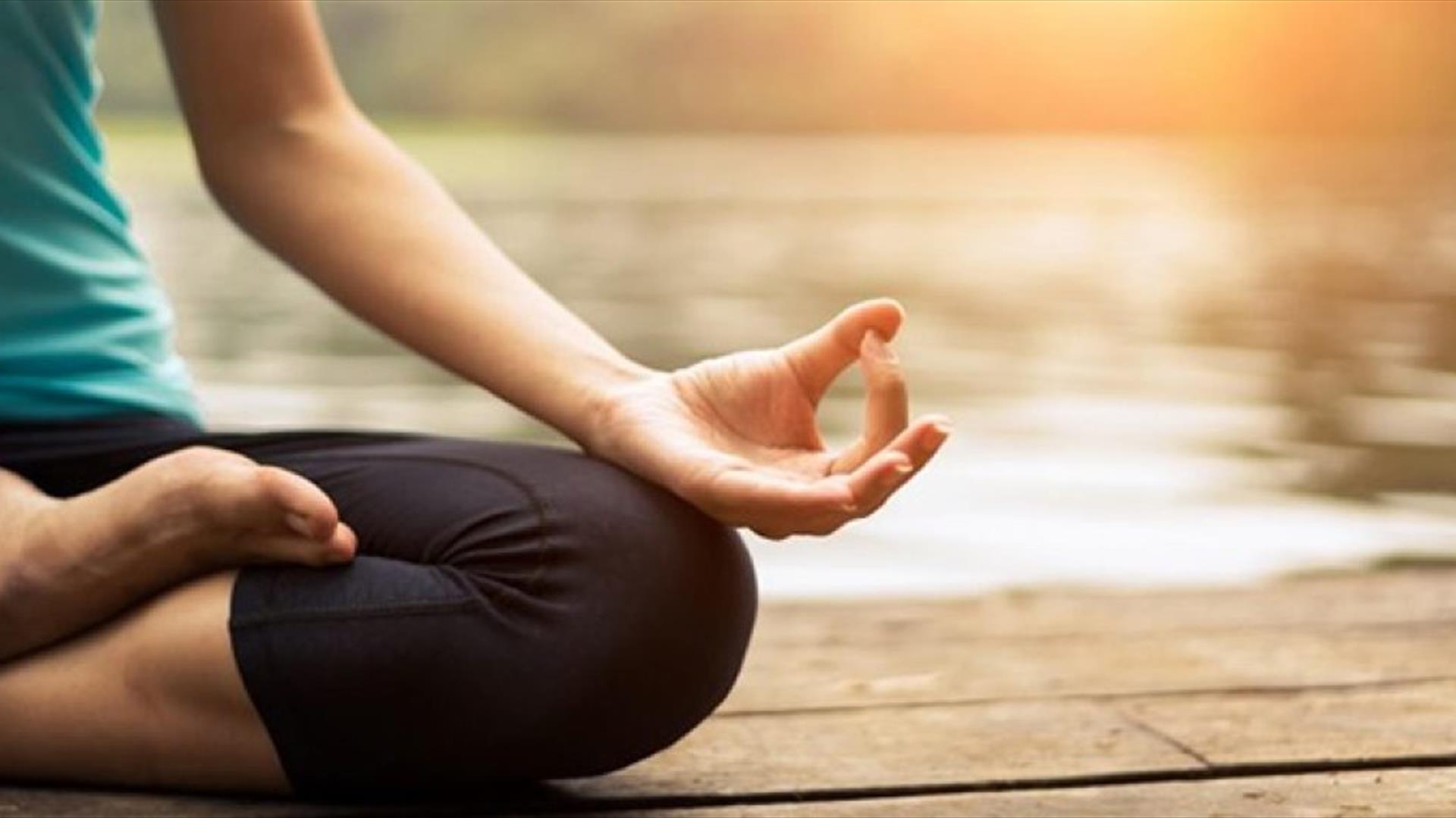 woman doing yoga beside a lake