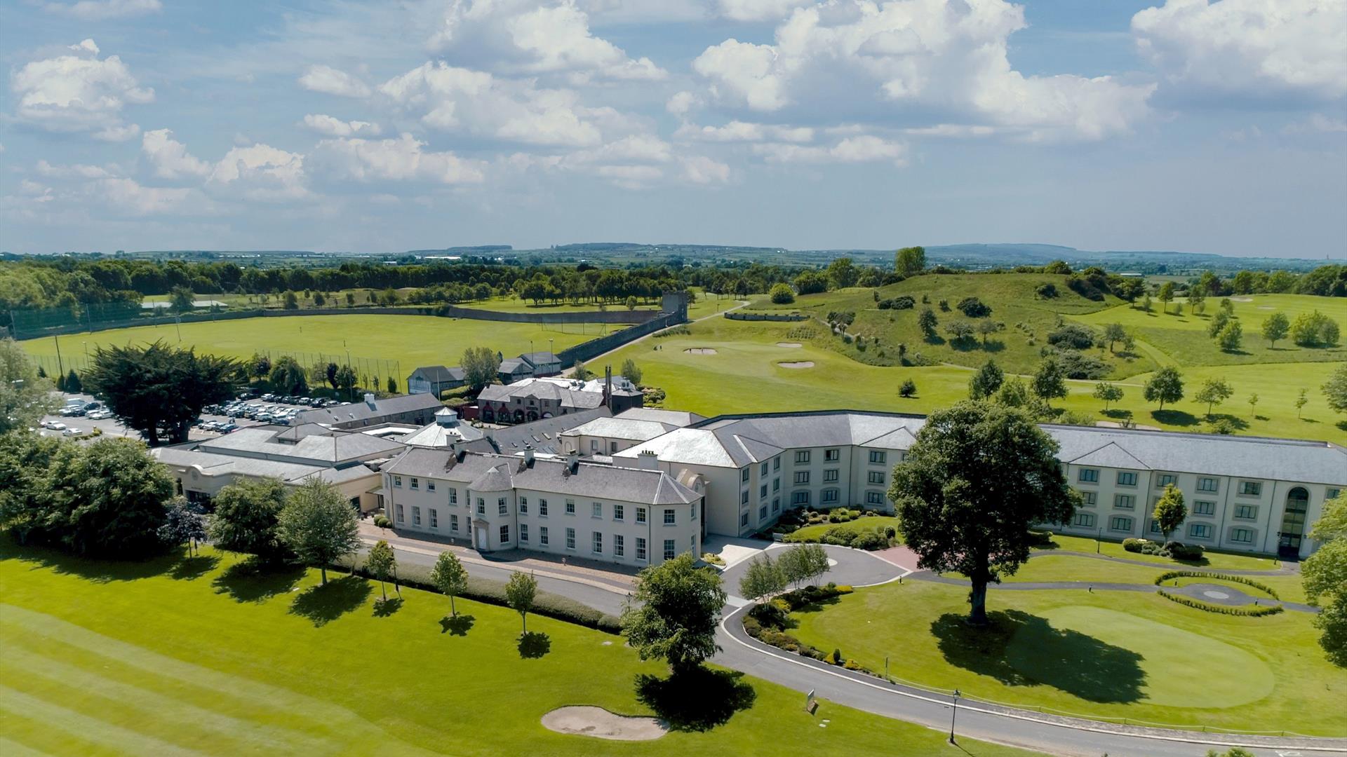 Drone view of the exterior at Roe Park Resort, fluorescent green natural surroundings and golf course.