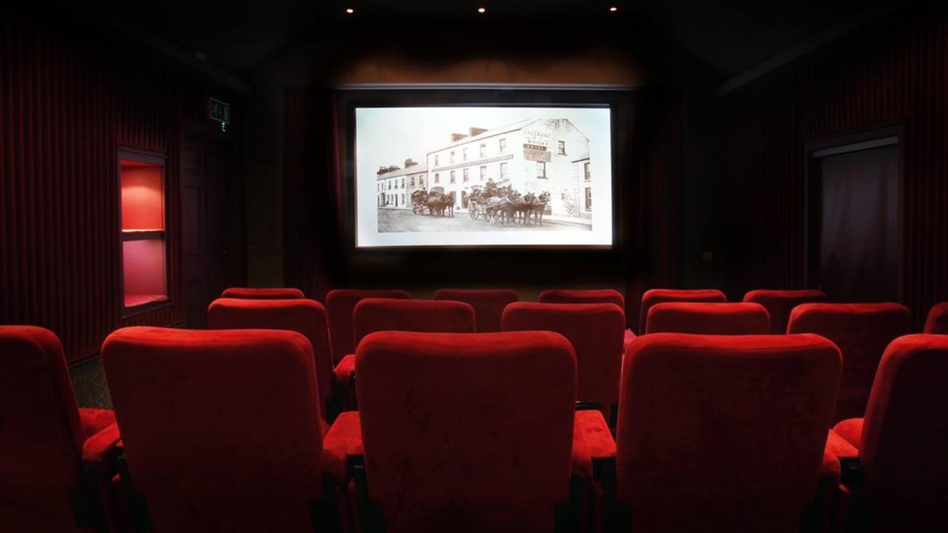 Image shows a movie theatre with red seats
