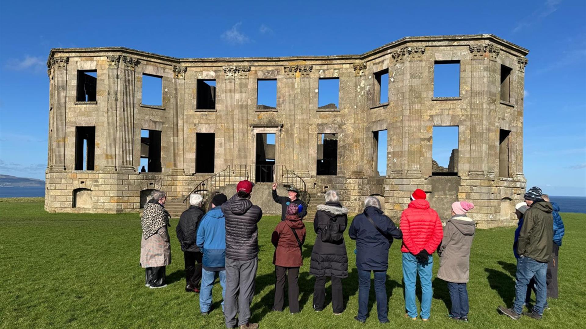 a group enjoy a tour on the grounds of Downhill Demesne