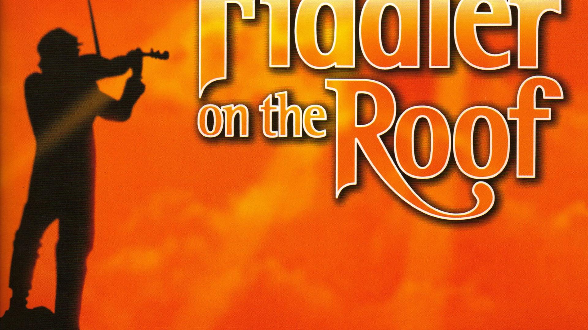 Man playing a fiddle on top of a mountain with the title 'Fiddler on the Roof'