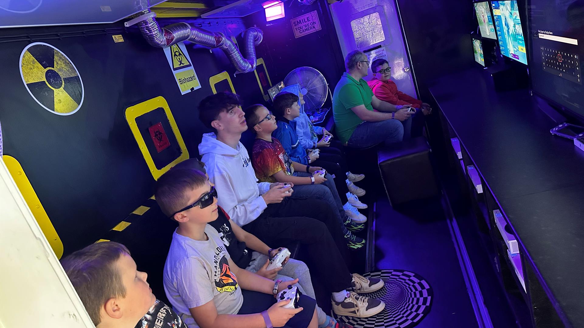 group of people playing games with various screens in front of them