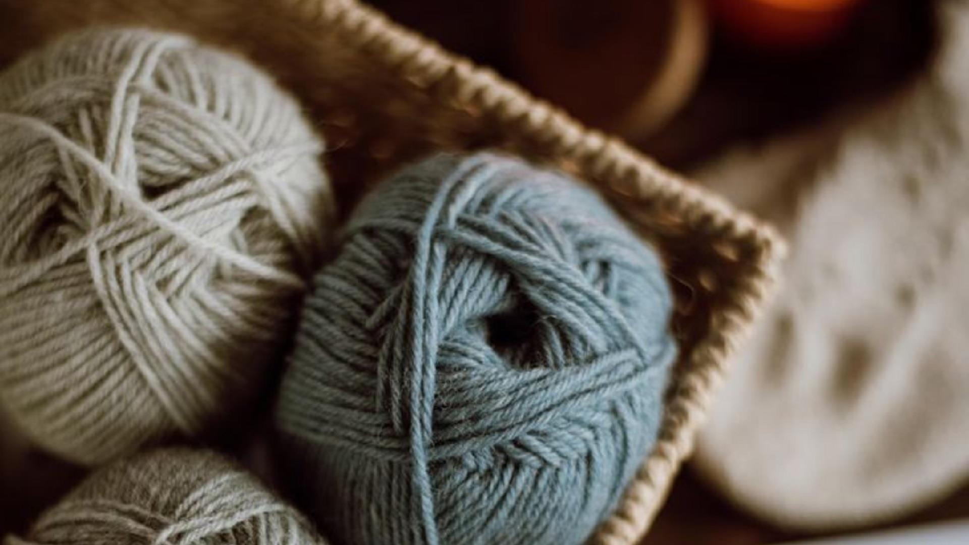 balls of wool sitting in a woven basket