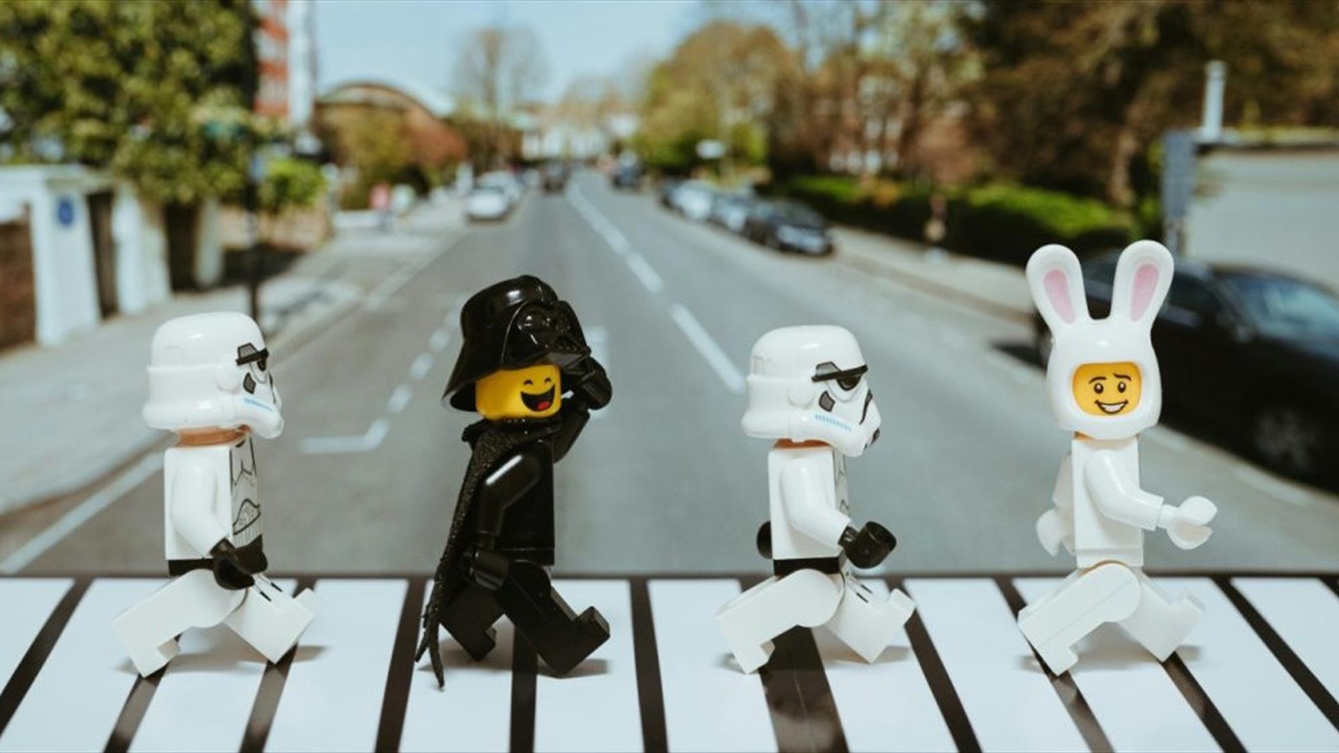 lego figures crossing a road, reminiscent of the famous beatles album cover