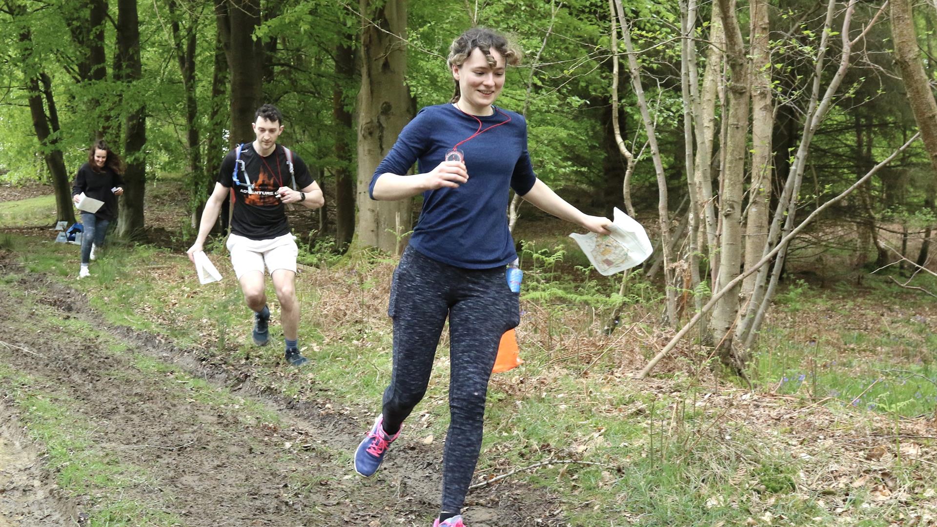 a group of people orienteering in the forest