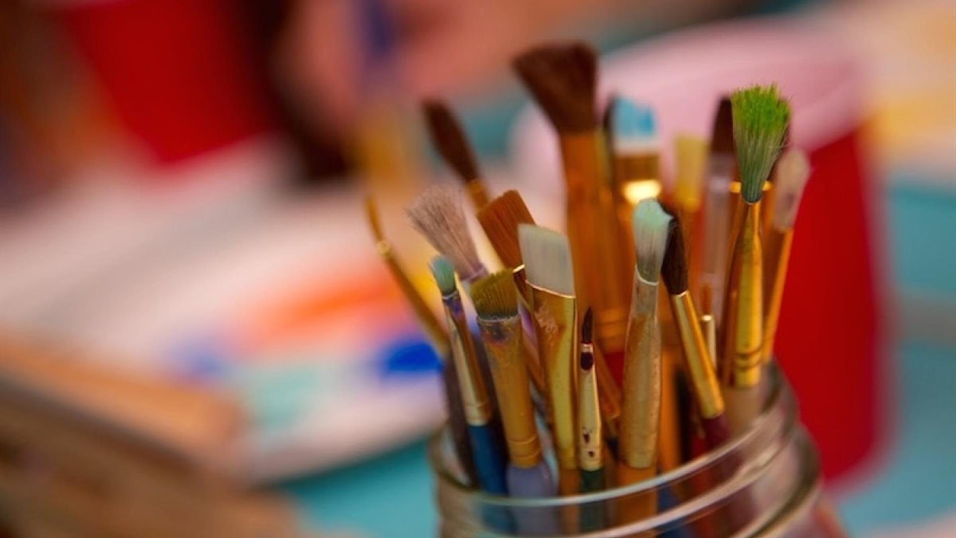 paintbrushes all bunched together in a pot