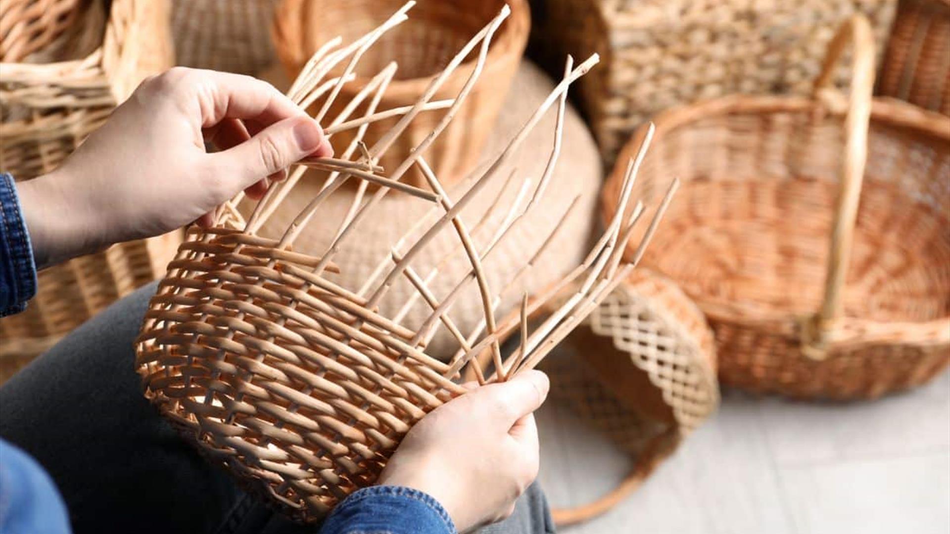 A basket being woven by hand. A collection of these baskets is visible in the background.