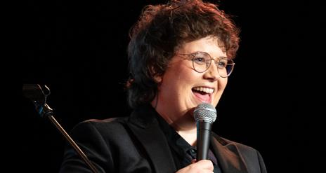Picture of Emer Maguire laughing holding a microphone.