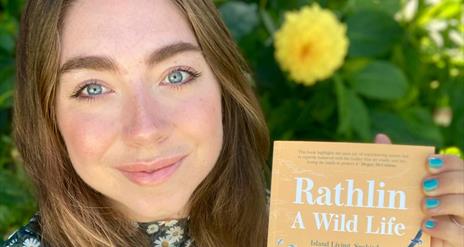 Ruby Free holding up her book, "Rathlin Wildlife" for the camera.