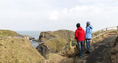 Two visitors admiring the views of Carrick-a-Rede Rope Bridge