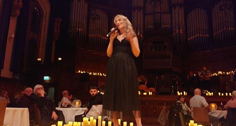 singer on stage surrounded by candles