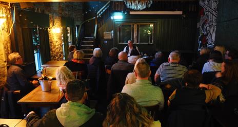 people gathered inside a bar as part of a tour group