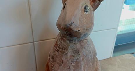 A brown hare sculpted entirely from clay.