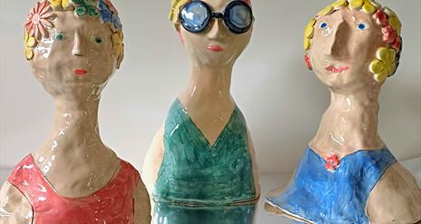 Three ceramic "Sea Swimmer" decorations, depicting various old fashioned bathing suits.