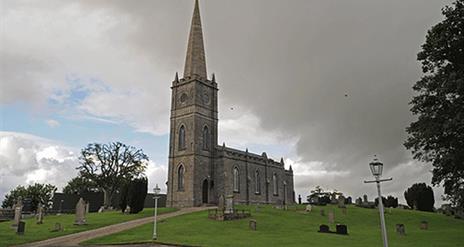 Tamlaght Finlagan Old Church, grey clouds and trees in the background.