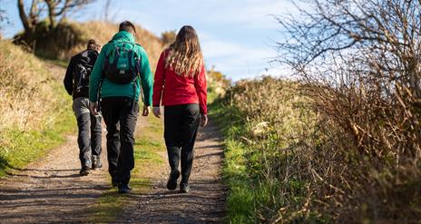 people walk on a rural hiking trail