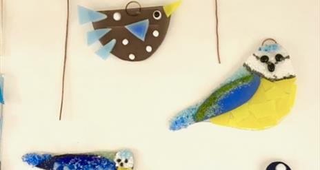 Various glass birds, all painted to resemble different species.