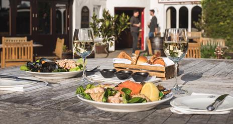 Food and wine on an outside table behind the Bushmills Inn.