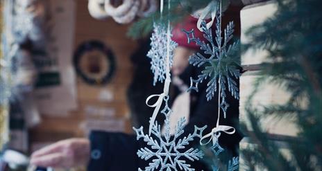 decorative snowflakes hang from a market stall