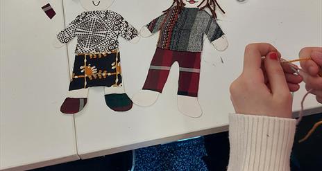 Small cutouts of little people, made from textiles like wool and linen.