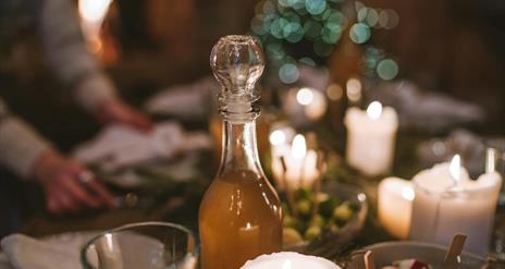 a twinkly festive picture of glass stopped bottle and candles.