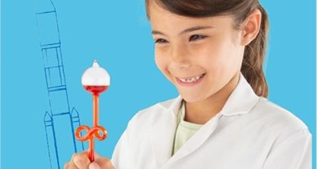 A smiling child holding some science equipment
