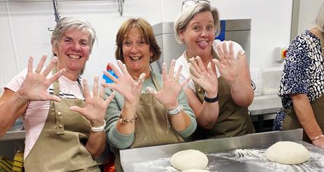 women cooking sourdough with flour all over their hands