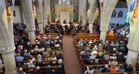 The ulster orchestra performs in the hall of St. Patrick's and St. Brigid's church.