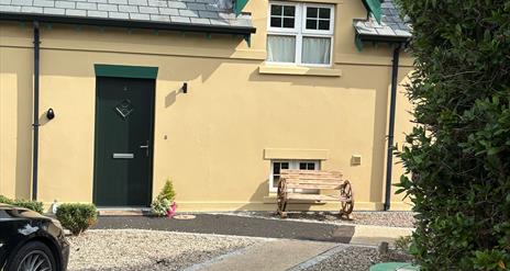 Photograph of front of The Distillers View, bench and plant