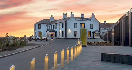 The Causeway Hotel bar accompanied by a beautiful pink and orange sunset in the background.