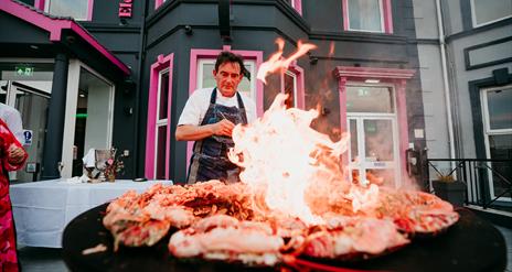 Stephane Delourme at Elephant Rock Hotel, cooking up a plate of seafood with an open flame.