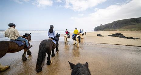 a group of people on horseback on Downhill Beach