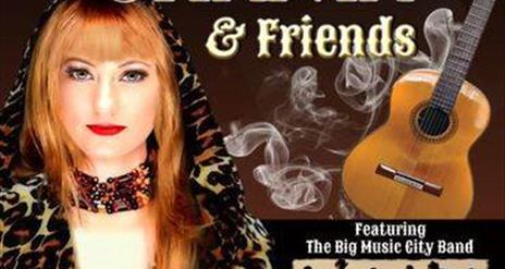 Image of a woman in a leopard print jacket with hood and a guitar