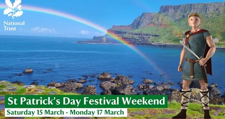 Finn McCool standing on the Grand Causeway, with a clear blue sky and double rainbow in the background and the Causeway Cliffs. Advertising a St Patri
