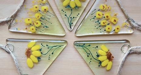 A beautiful glass bunting decorated with painted sunflowers.