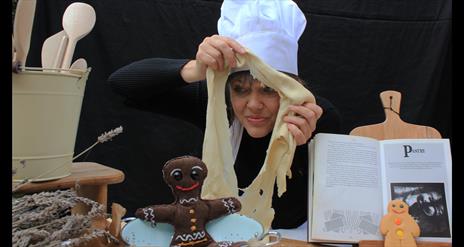 A woman in a chef's hat with pastry.
